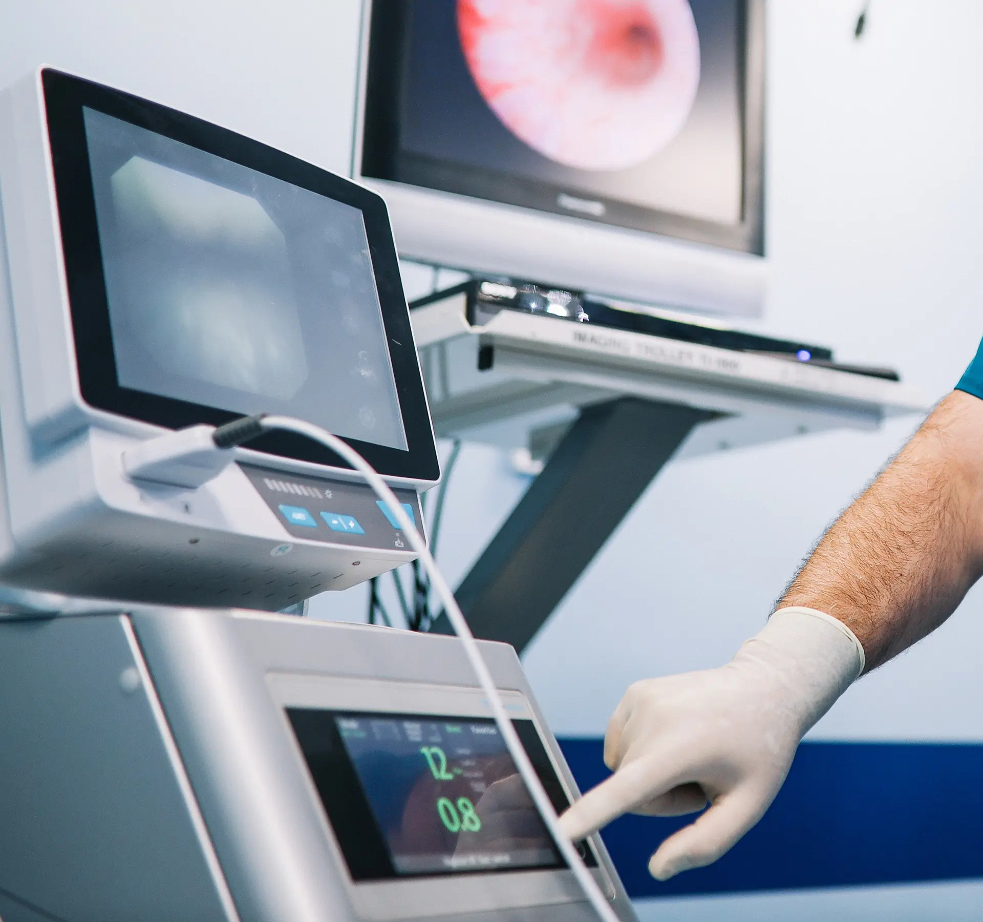 Gloved hand adjusting medical device settings