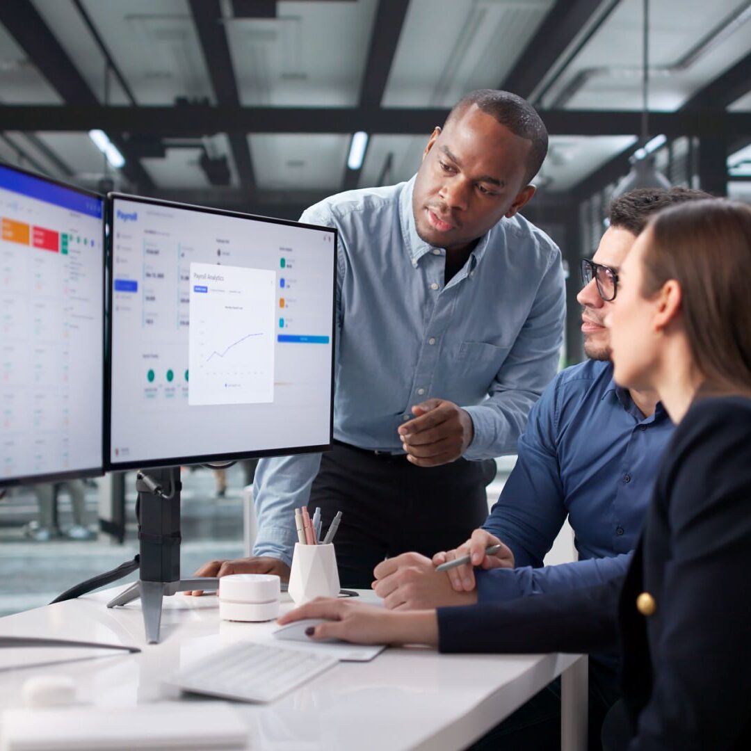 Team analyzing data on dual monitors