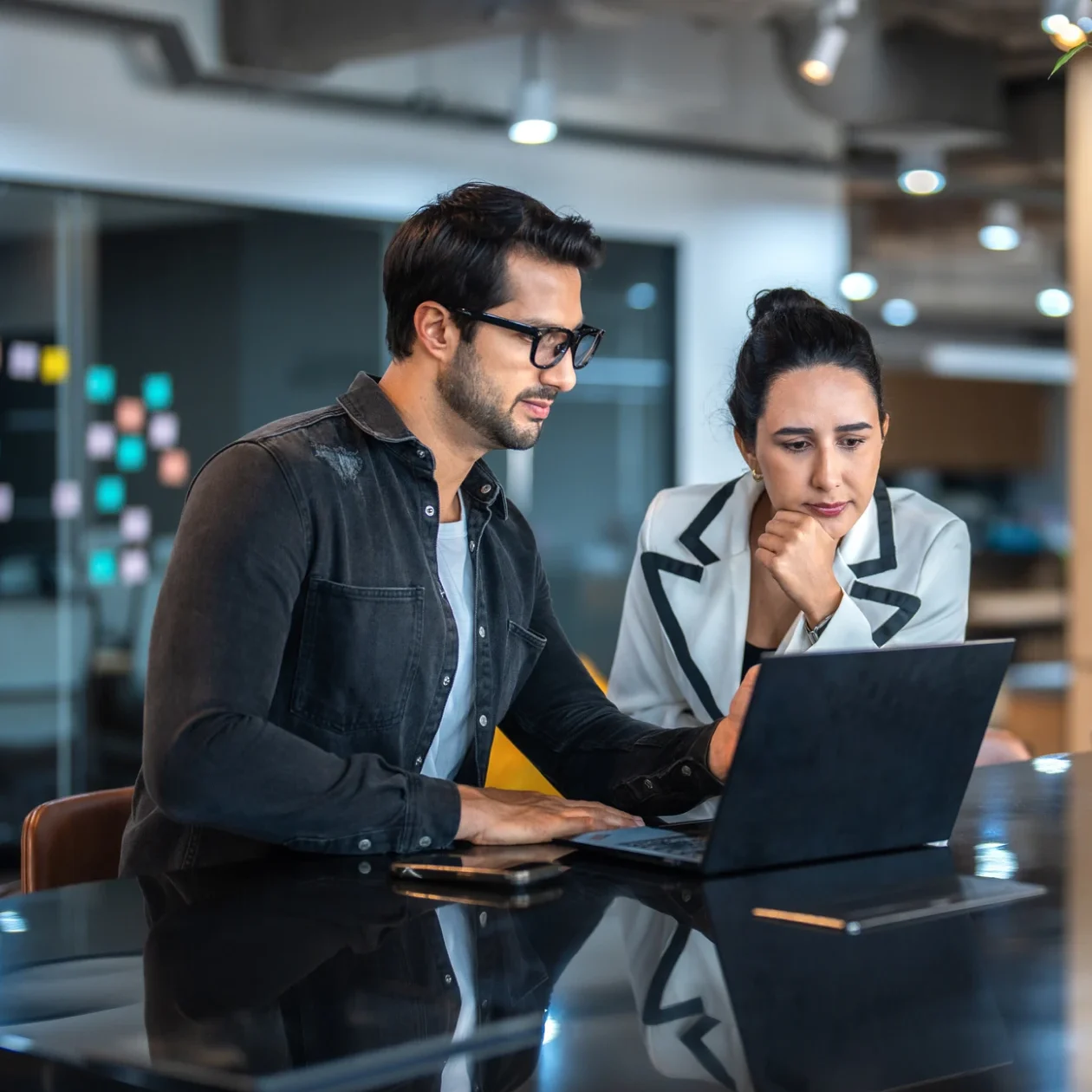 Two people discussing work at desk